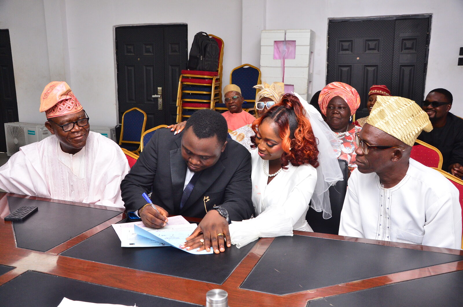 Oluwafunmibi and Olumurewa signing their wedding documents